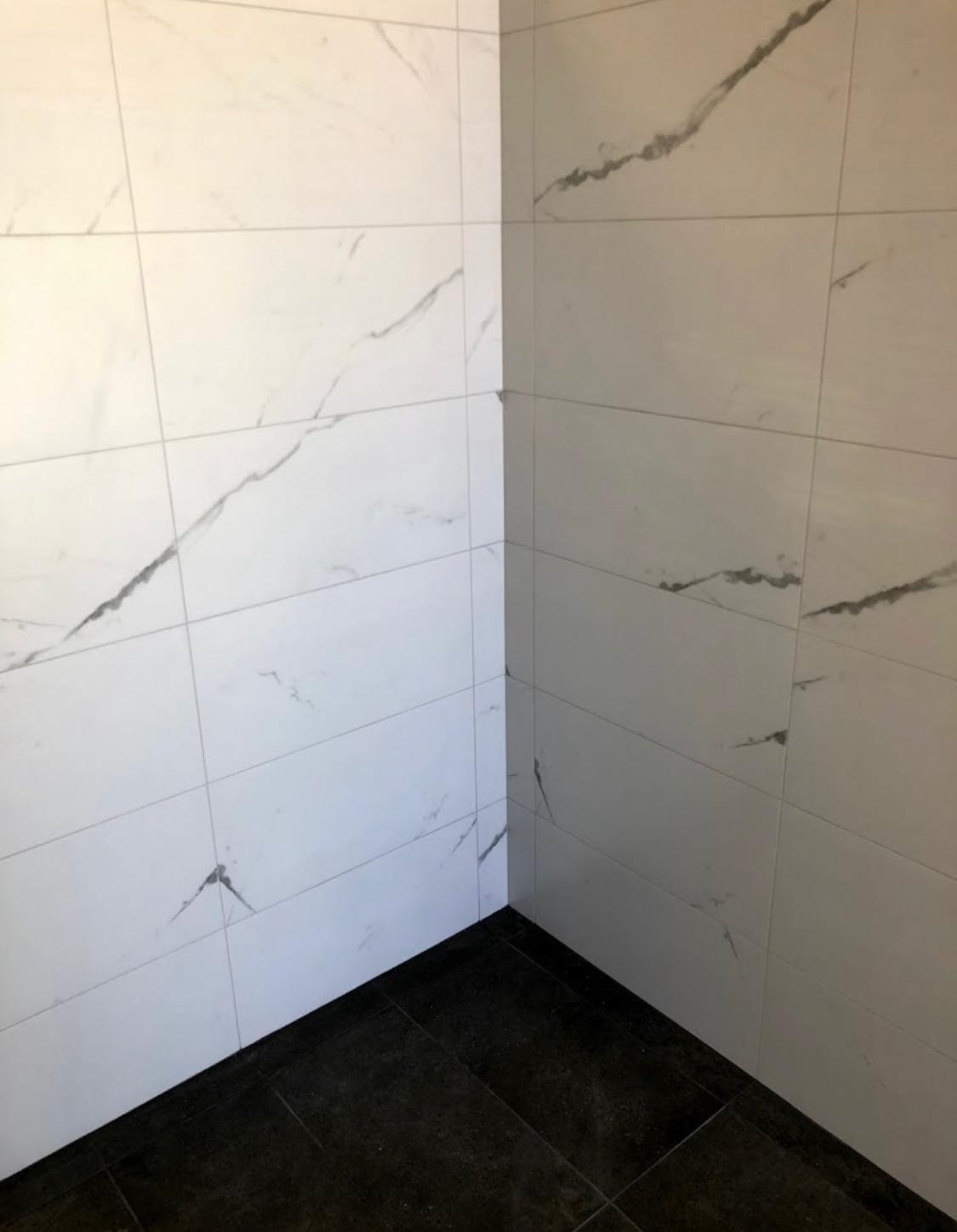 Marble-look shower walls with black floor tiles — Perth Tiling WA project